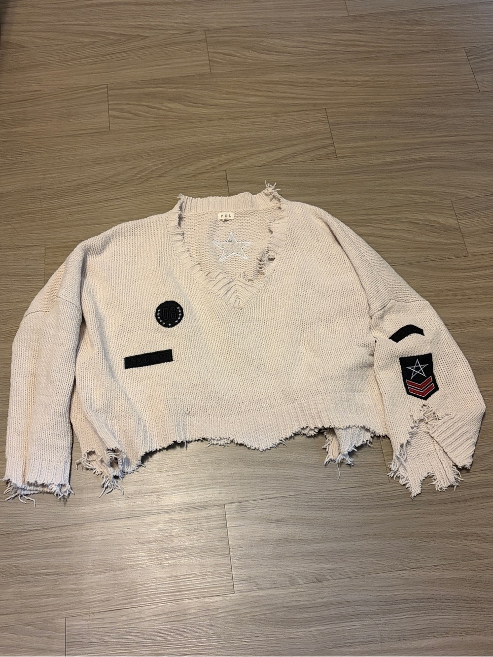 POL Cropped Distressed V-Neck Sweater in Light Beige with Black Patch Accents